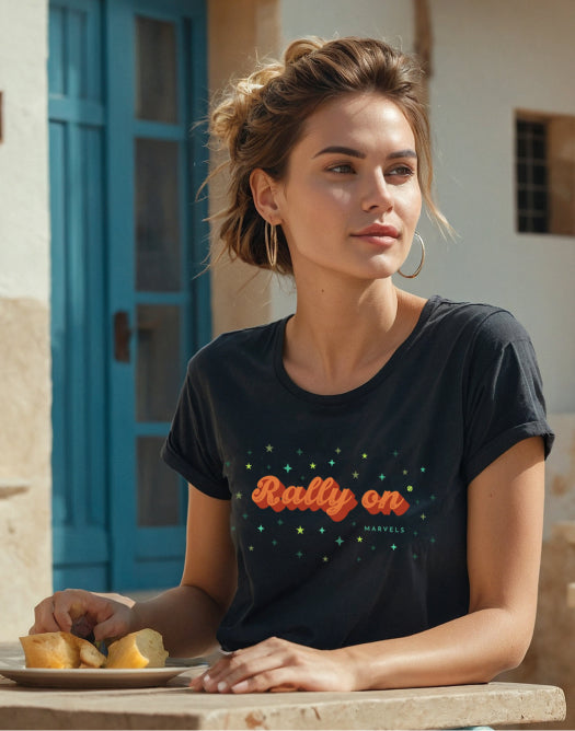 Woman seated at a cafe wearing the Rally On t-shirt