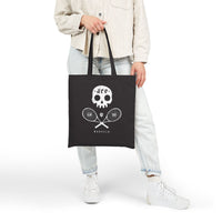 Person holding a black tote bag with a skull and tennis graphic on a white background