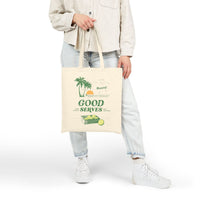 Person holding a tote bag with a palm trees graphic and text that reads 'Good Serves' on a white background