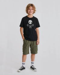 Child wearing a black t-shirt with a  skull and crossed tennis rackets graphic design and green cargo shorts on a white background