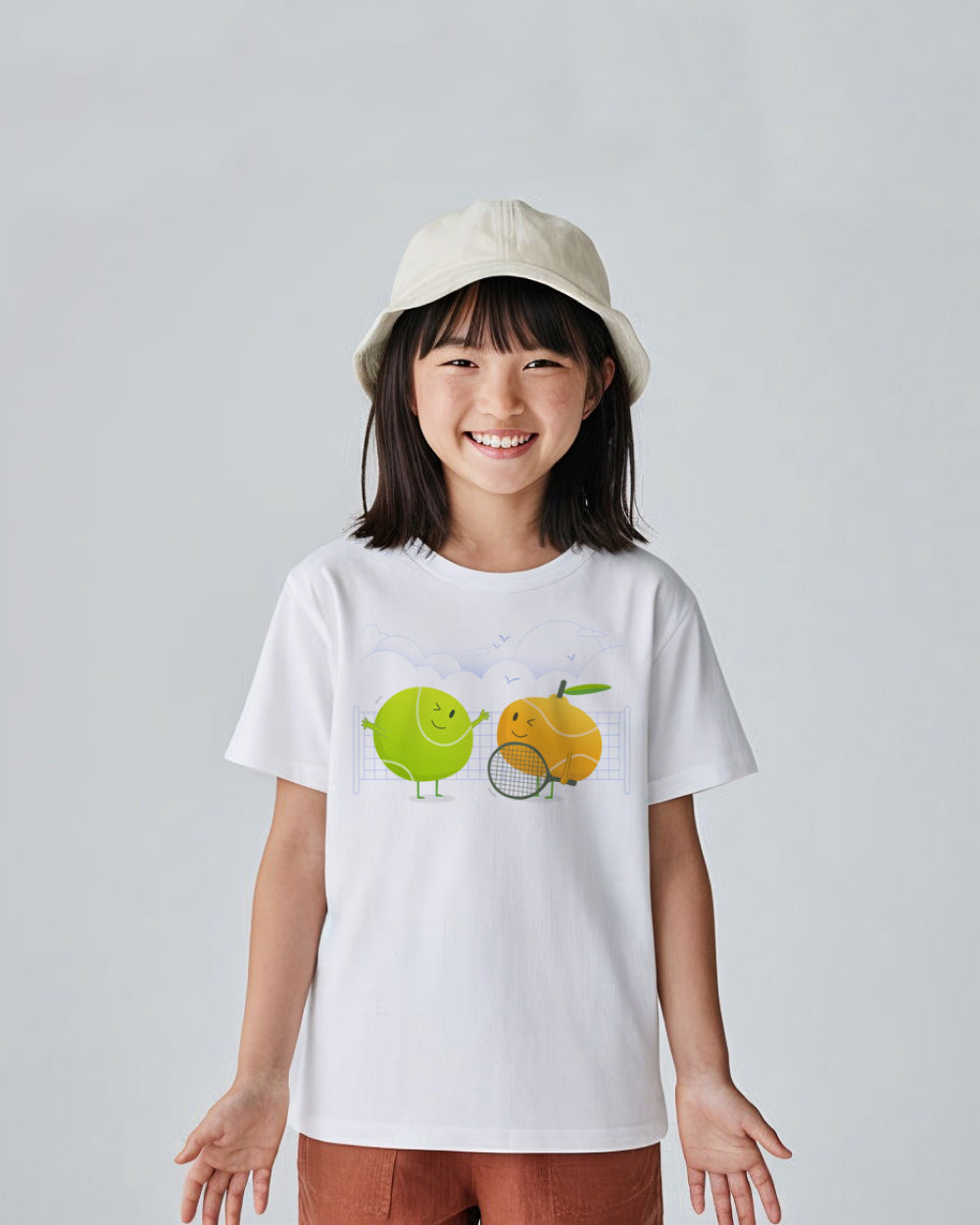Child wearing a white t-shirt with a tennis graphic design on a plain background