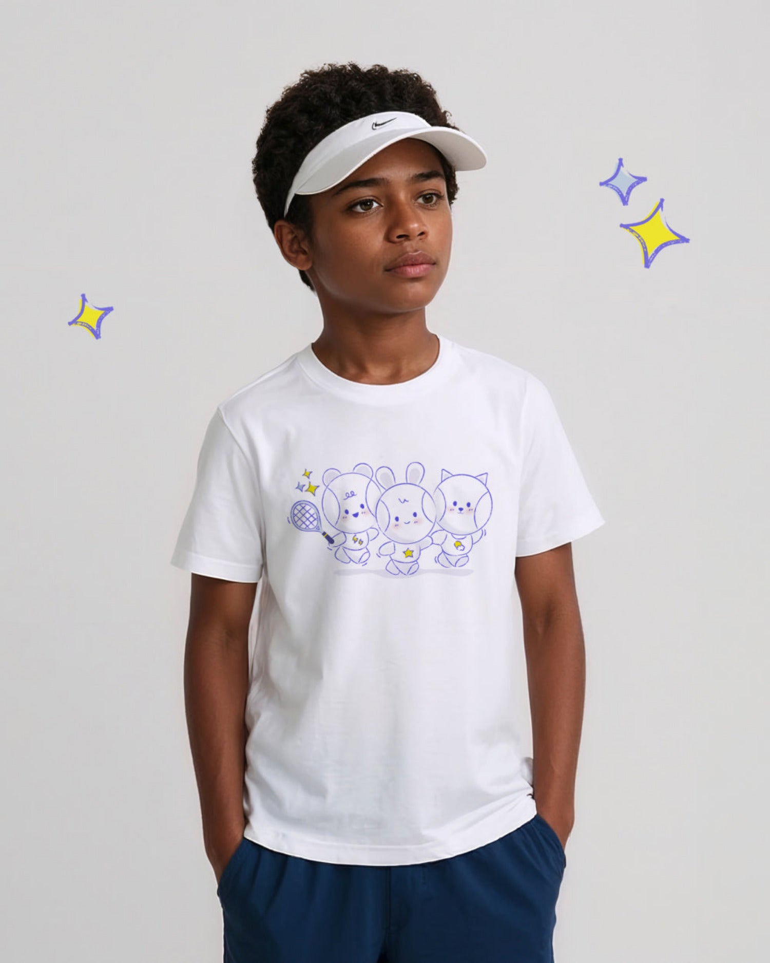 Child wearing a white t-shirt with cartoon tennis ball designs and a visor