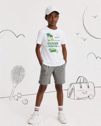 Child wearing a white t-shirt with graphics and text, standing against a white background with tennis-related illustrations.