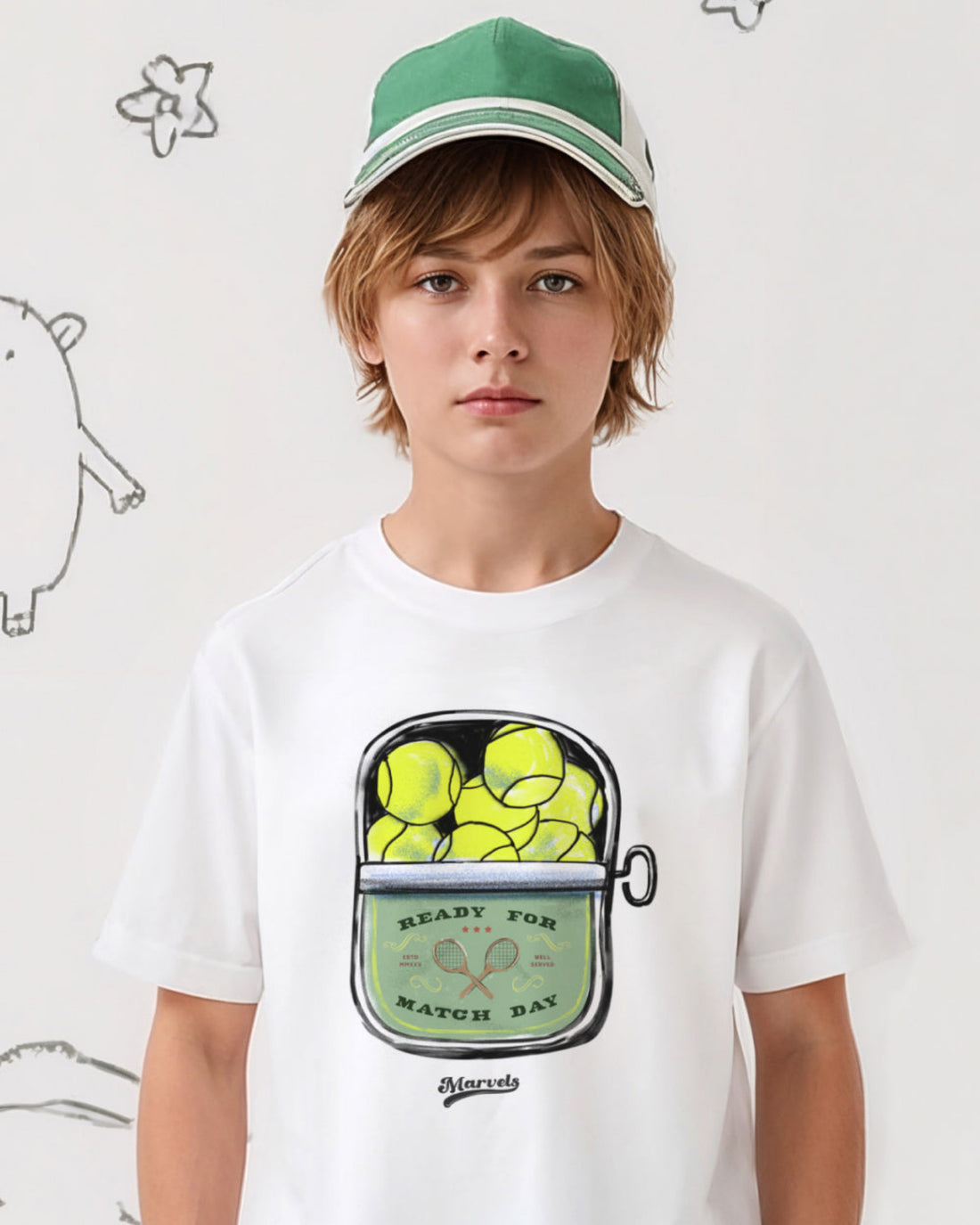 Child wearing a white t-shirt with a graphic design of tennis balls