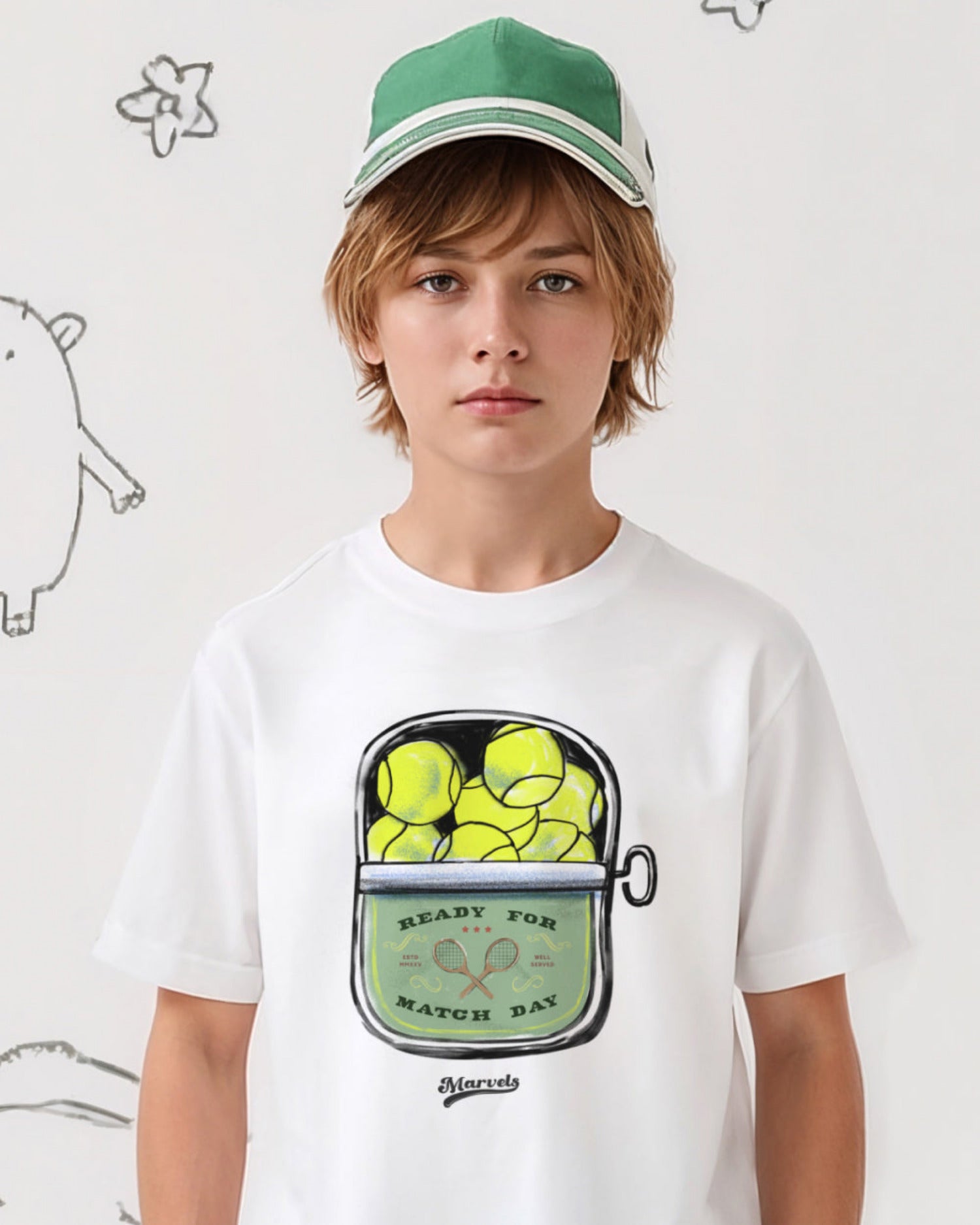 Child wearing a white t-shirt with a graphic design of tennis balls