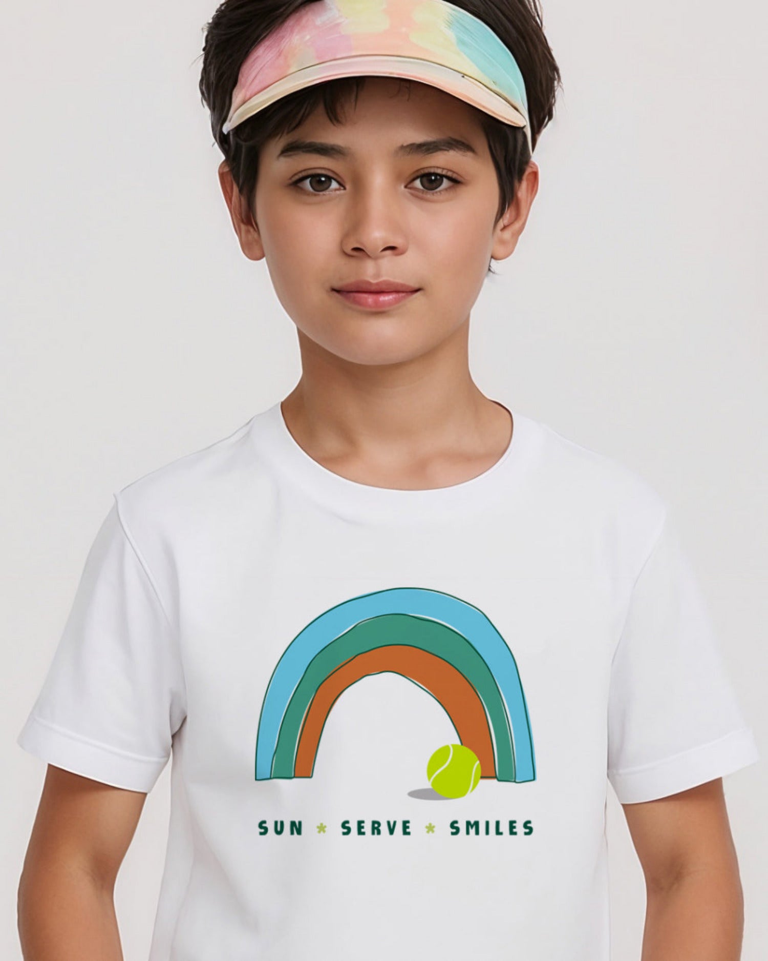 Child wearing a white t-shirt with a rainbow and tennis ball design