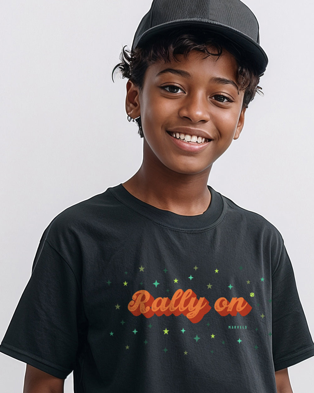 Child wearing a black t-shirt with 'Rally On' text and stars, smiling against a plain background