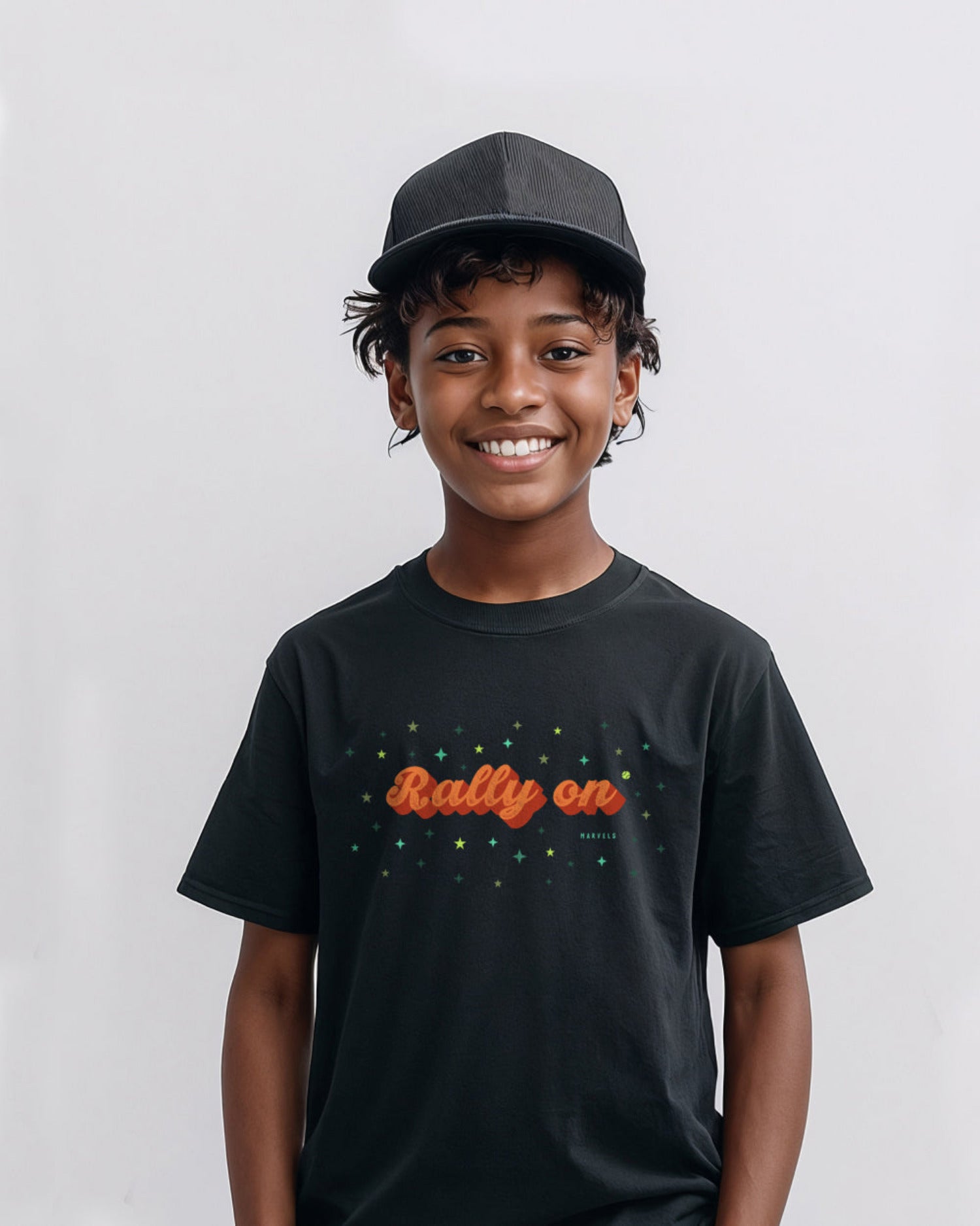 Child wearing a black tennis t-shirt with 'Rally on' text and a cap