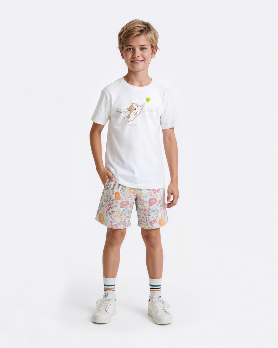 Child wearing a white tennis t-shirt with a cat graphic and patterned shorts