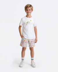Child wearing a white tennis t-shirt with a cat graphic and patterned shorts
