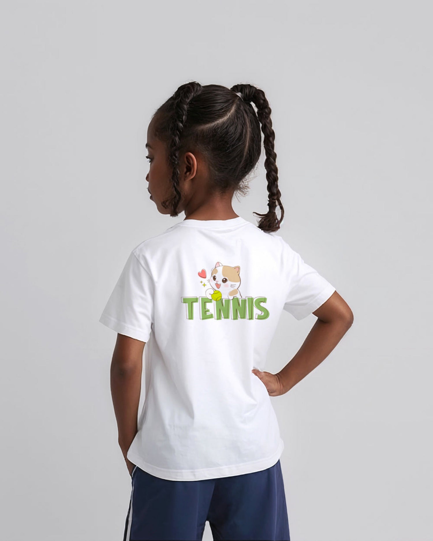 Child wearing a white t-shirt with 'Tennis' and a cartoon cat character on the back