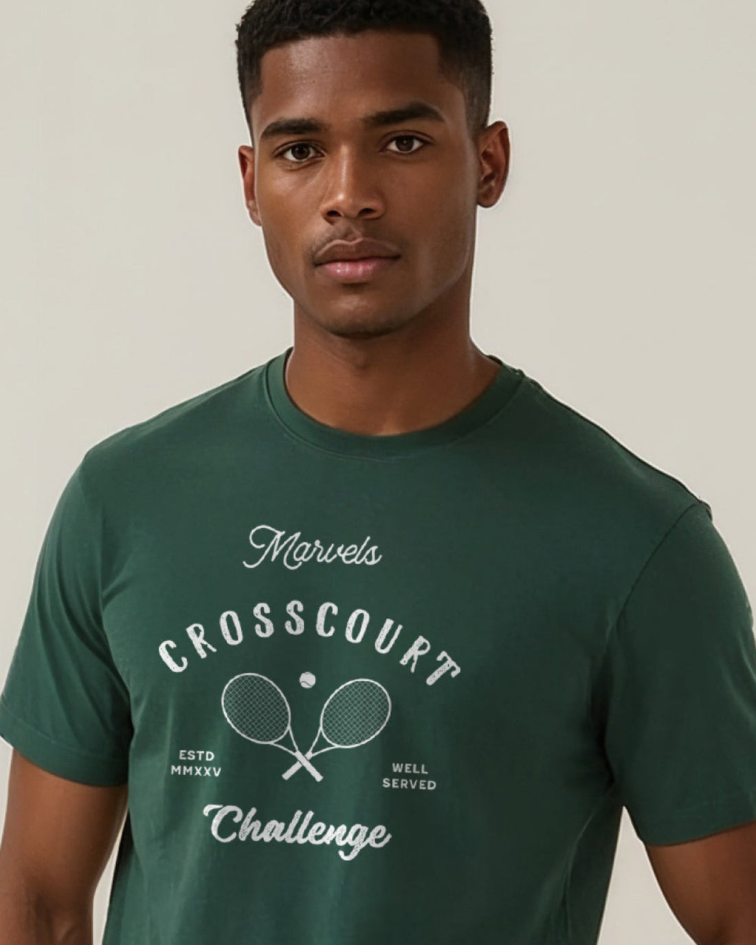Man wearing a green t-shirt with 'Marvels Crosscourt Challenge' text and graphic on a plain background