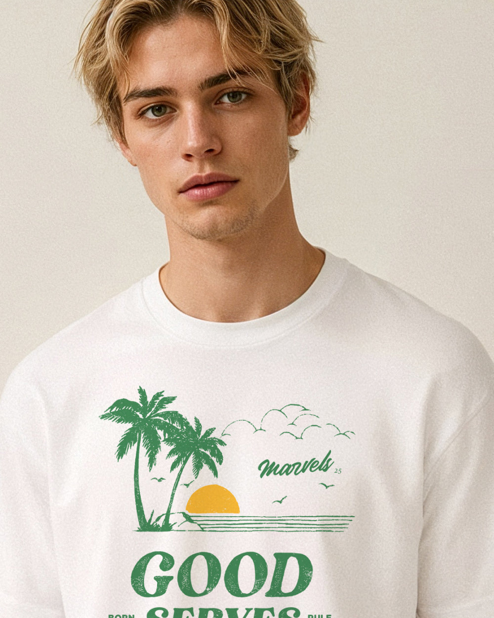 Person wearing a white t-shirt with a green palms and sunset graphic design on a plain background