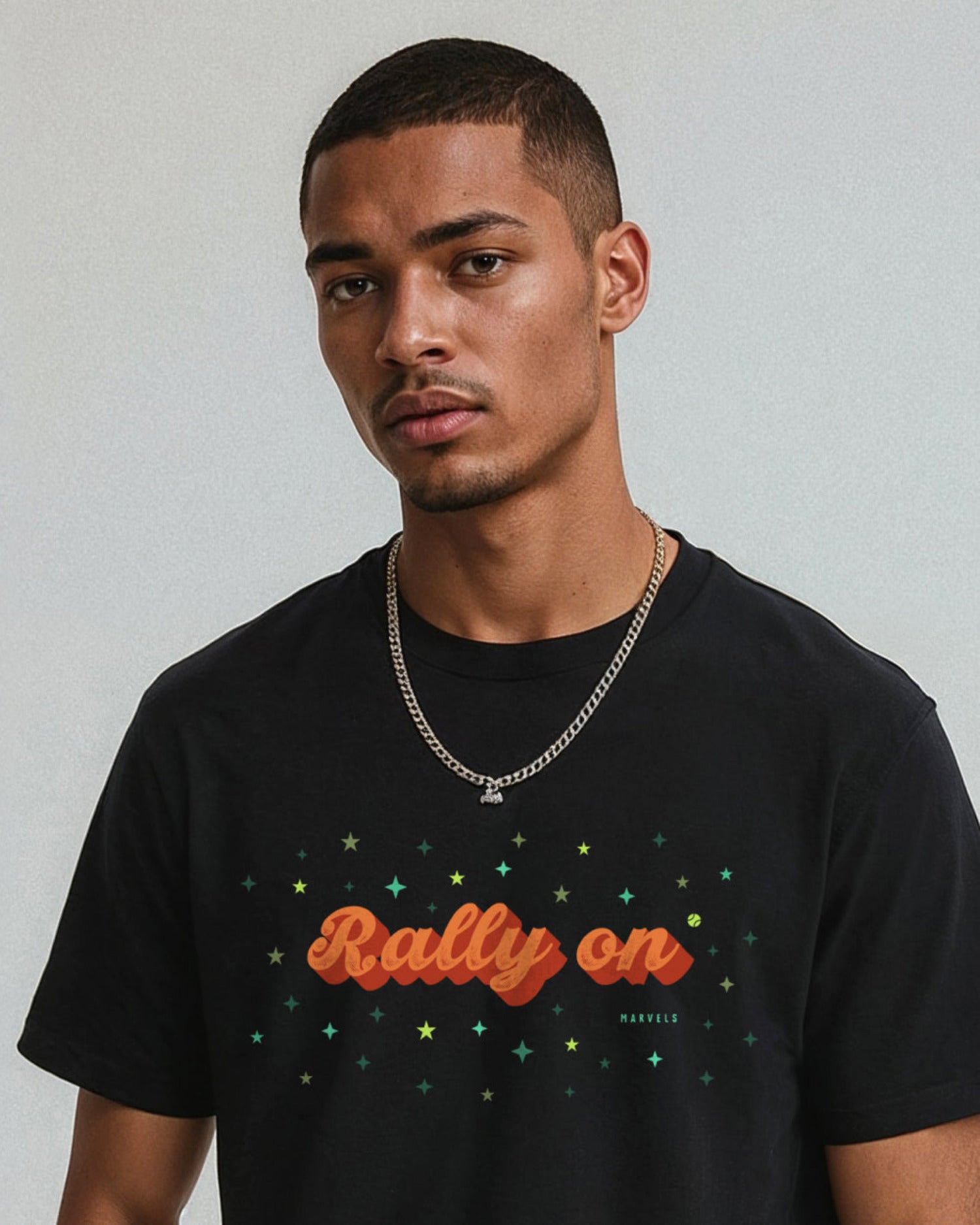 Man wearing a black t-shirt with 'Rally on' text and stars, standing against a plain background