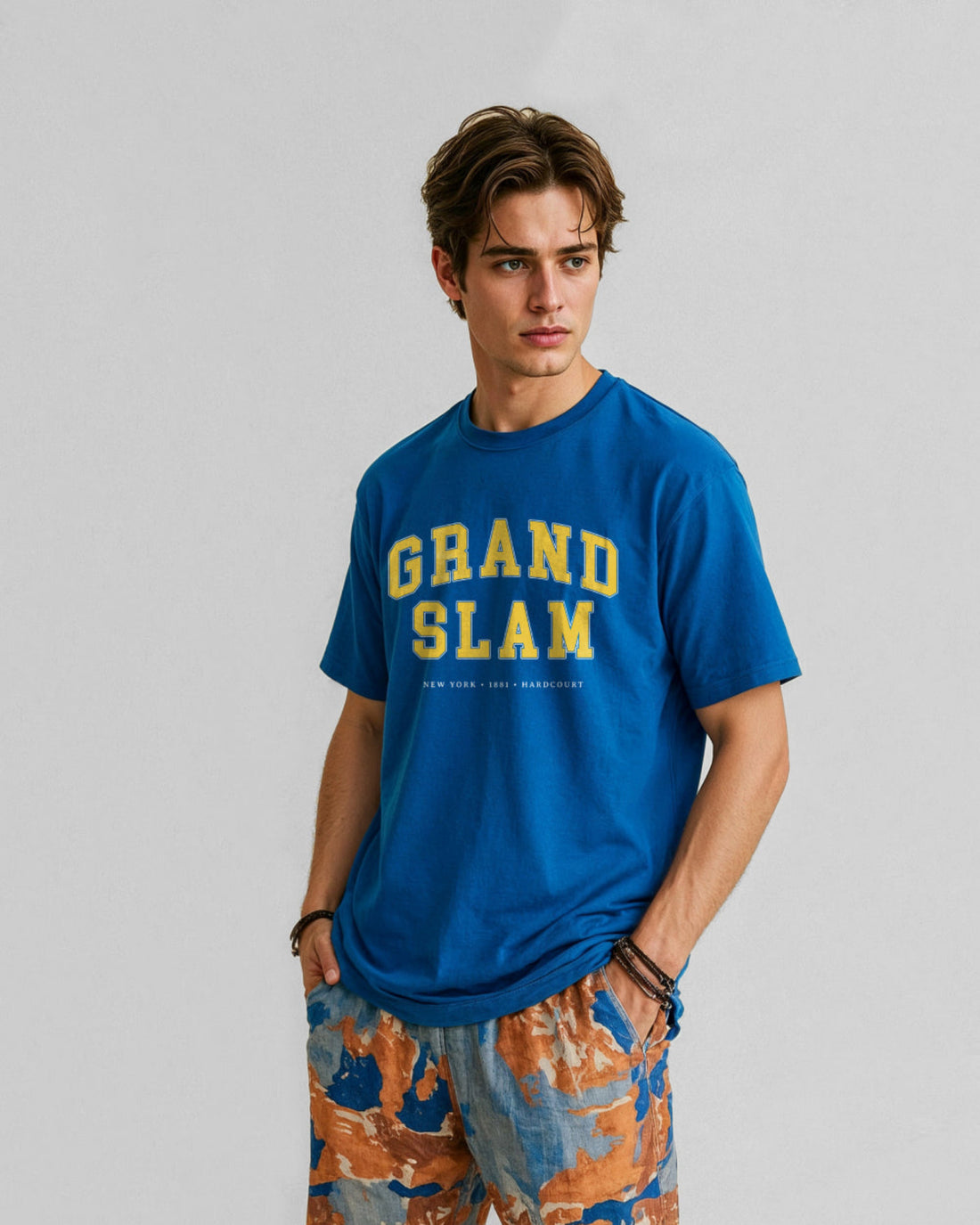 Man wearing a blue 'Grand Slam' t-shirt against a gray background