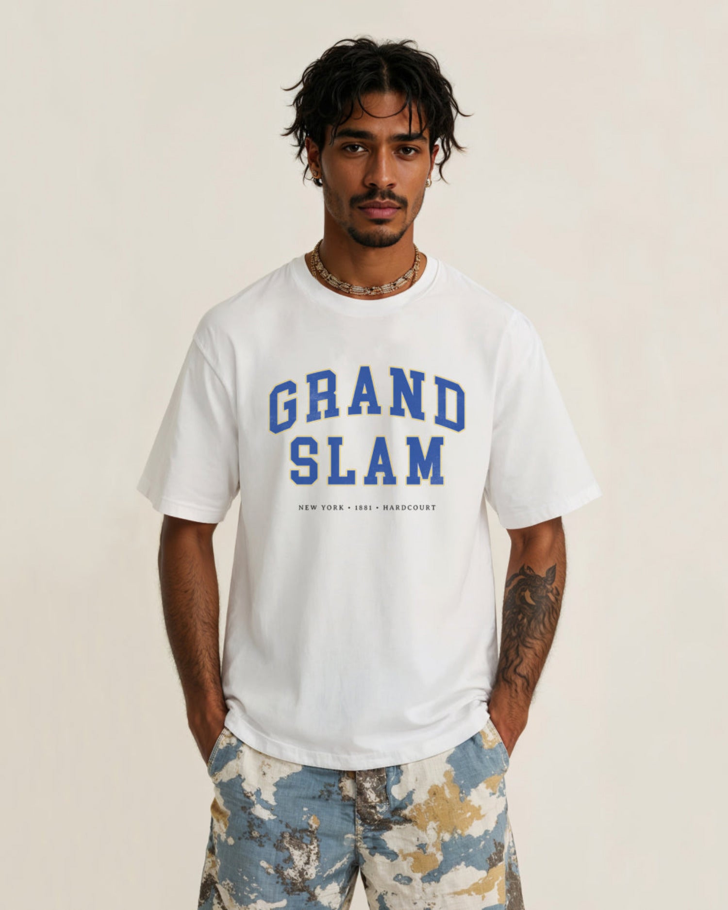 Man wearing a white t-shirt with 'Grand Slam' text on a beige background
