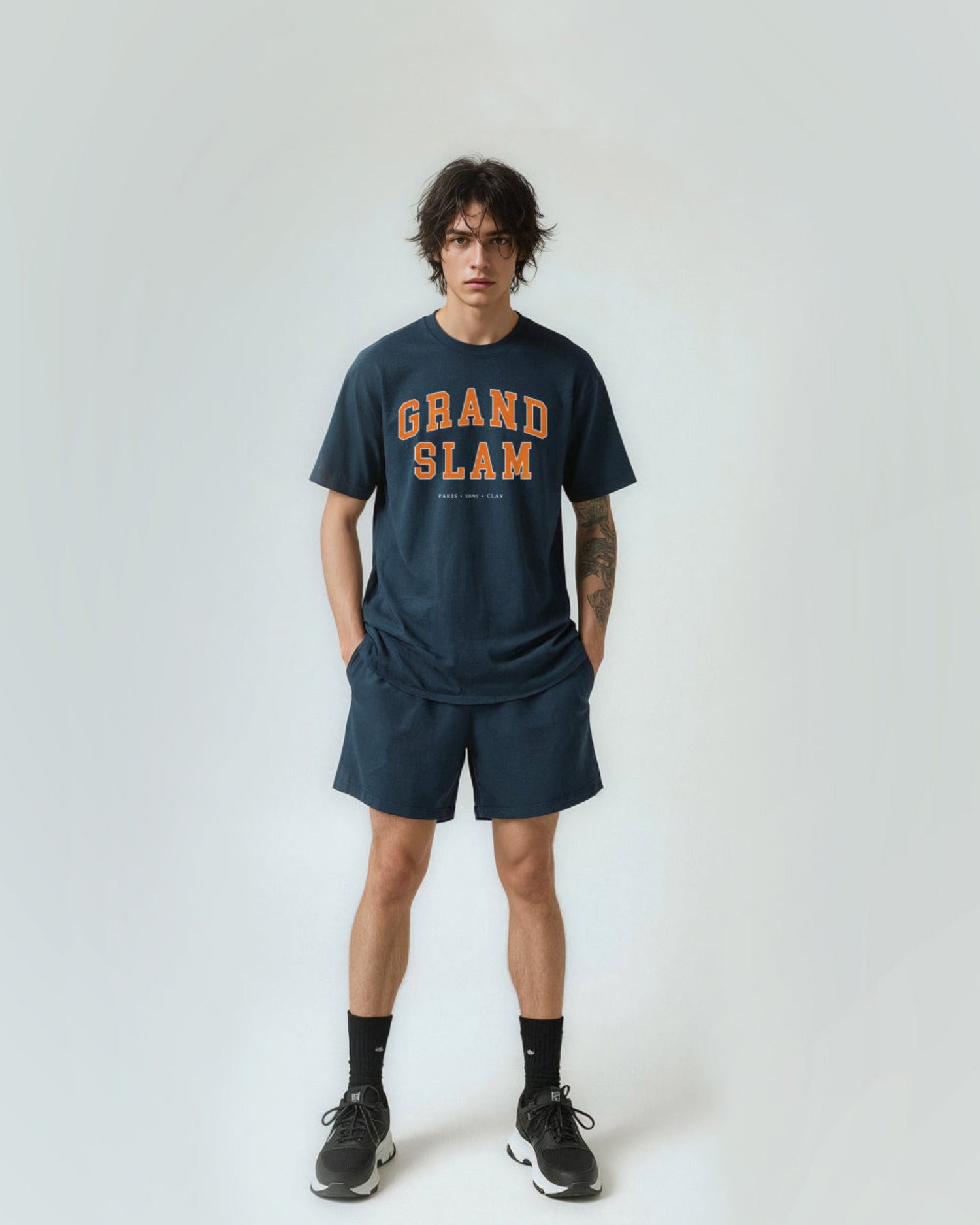 Person wearing a 'Grand Slam' t-shirt and shorts on a white background