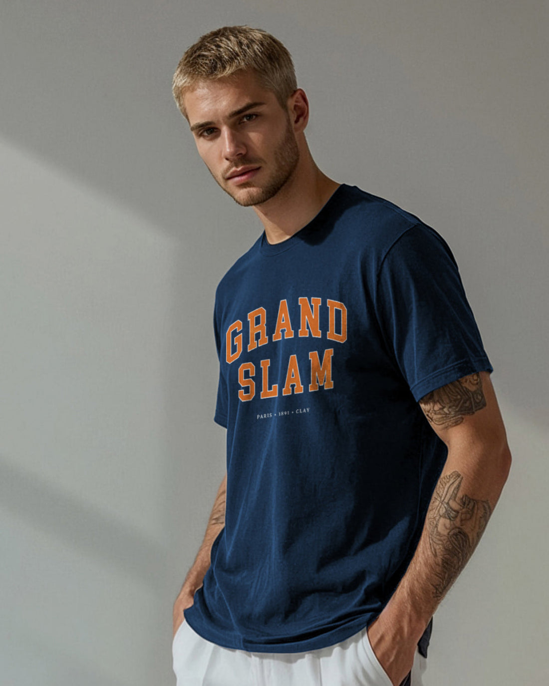 Man wearing a navy blue t-shirt with 'Grand Slam' text against a neutral background