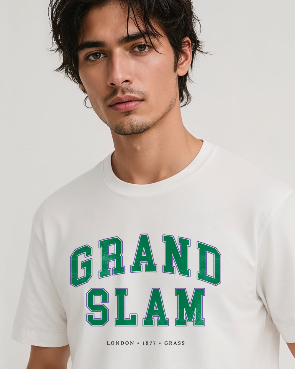 Man wearing a white t-shirt with 'GRAND SLAM' text on a plain background