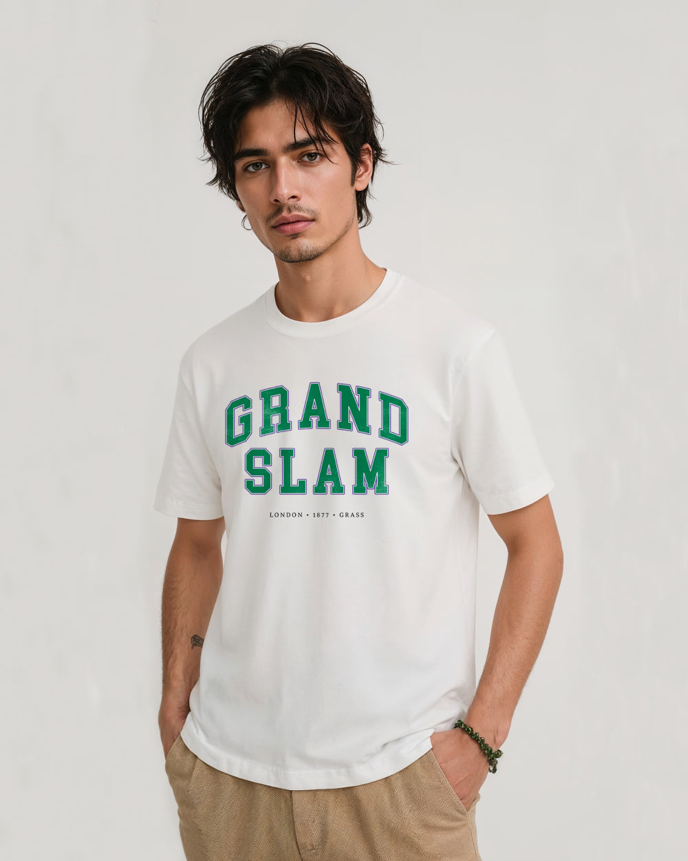 Man wearing a white t-shirt with 'Grand Slam' text on a plain background