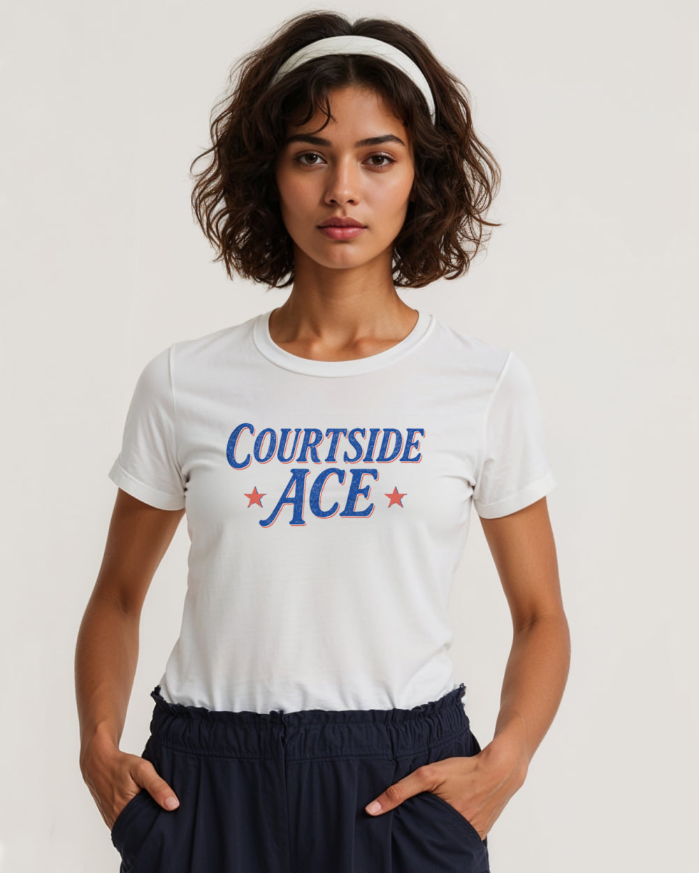 Woman wearing a white t-shirt with 'Courtside ACE' text on a plain background