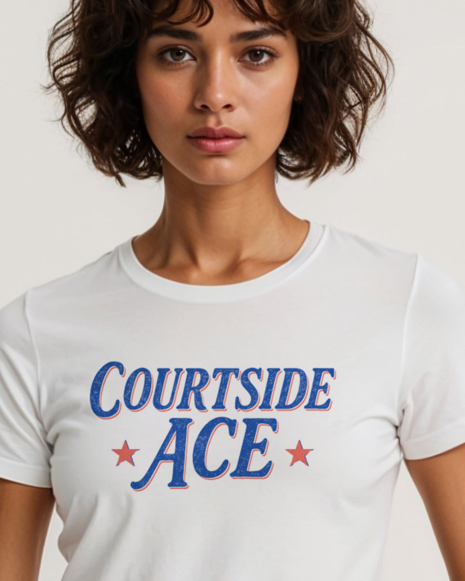 Person wearing a white t-shirt with 'COURTSIDE ACE' text and stars.