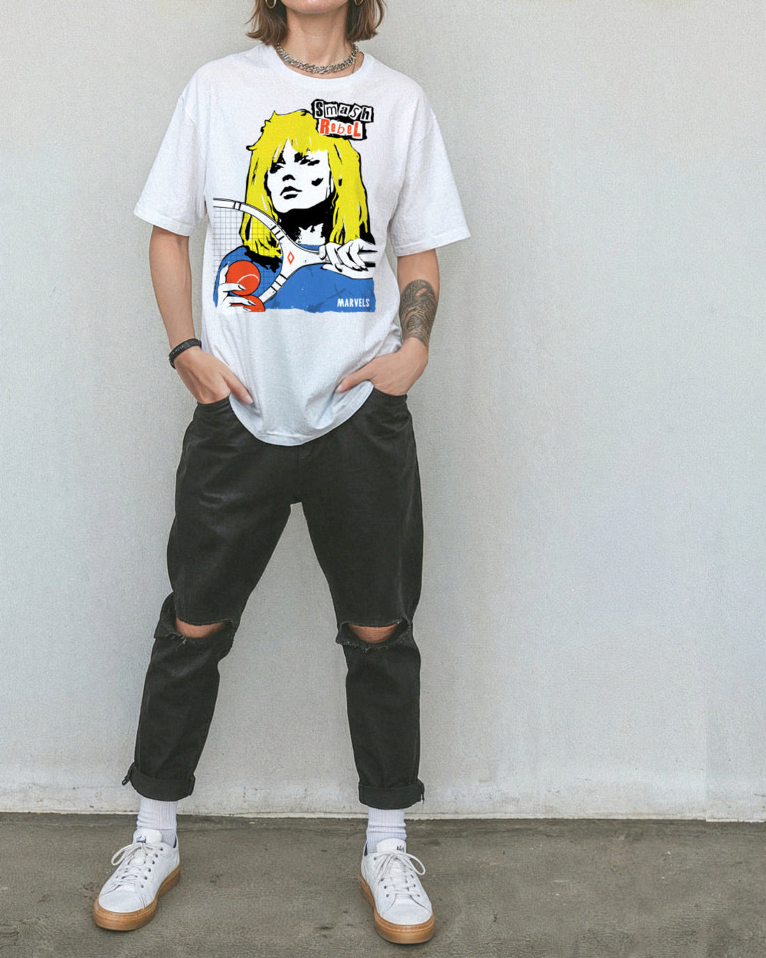 Person wearing black pants and a white t-shirt with a tennis-themed graphic that reads, 'Smash Rebel'.
