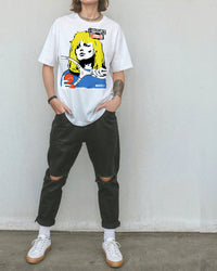 Person wearing black pants and a white t-shirt with a tennis-themed graphic that reads, 'Smash Rebel'.
