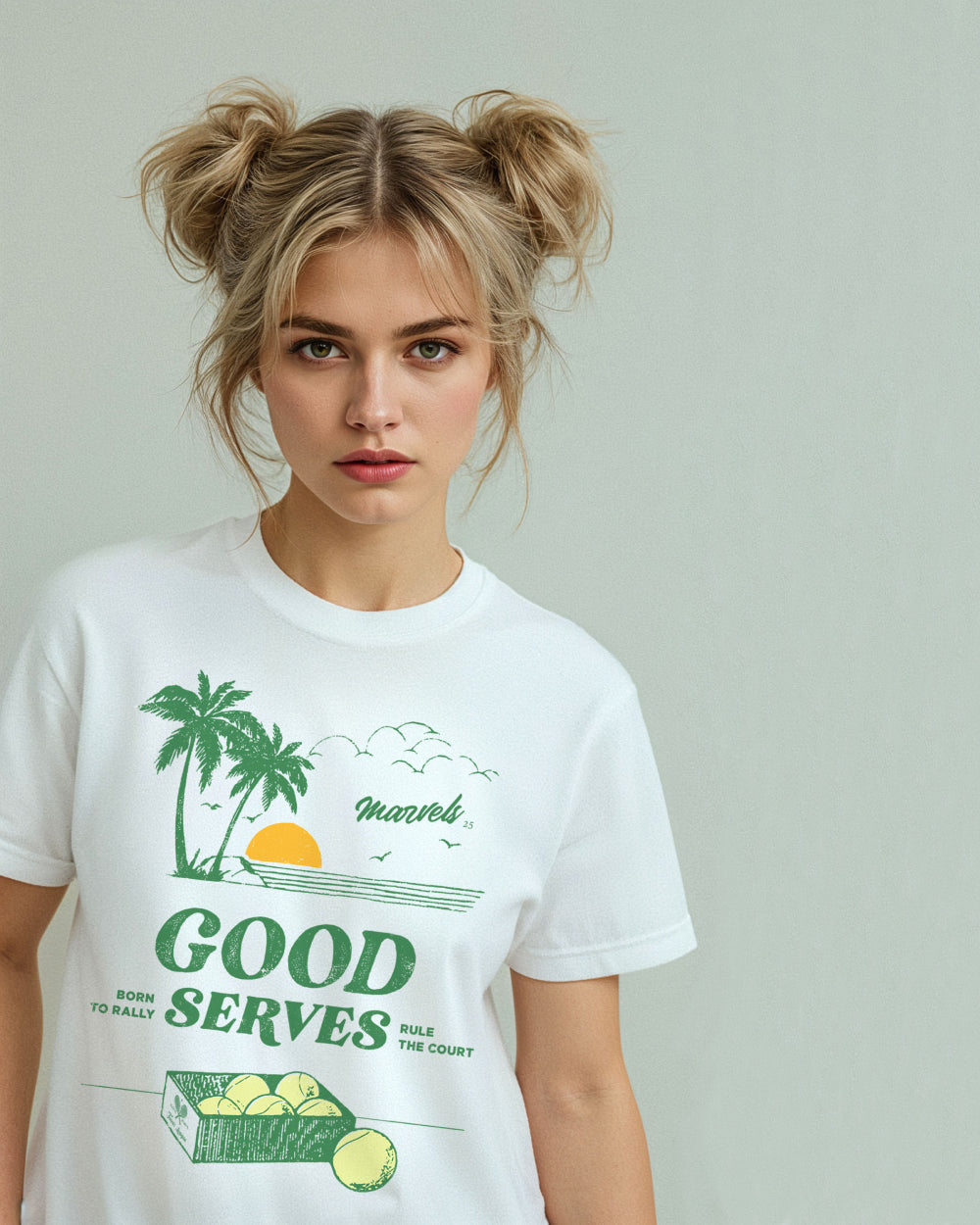 Person wearing a white t-shirt with a tennis graphic that reads 'Good Serves' in text on a plain background