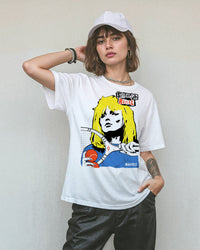 Model wearing black pants, a cap and a white t-shirt with a tennis-themed graphic that reads, 'Smash Rebel'.