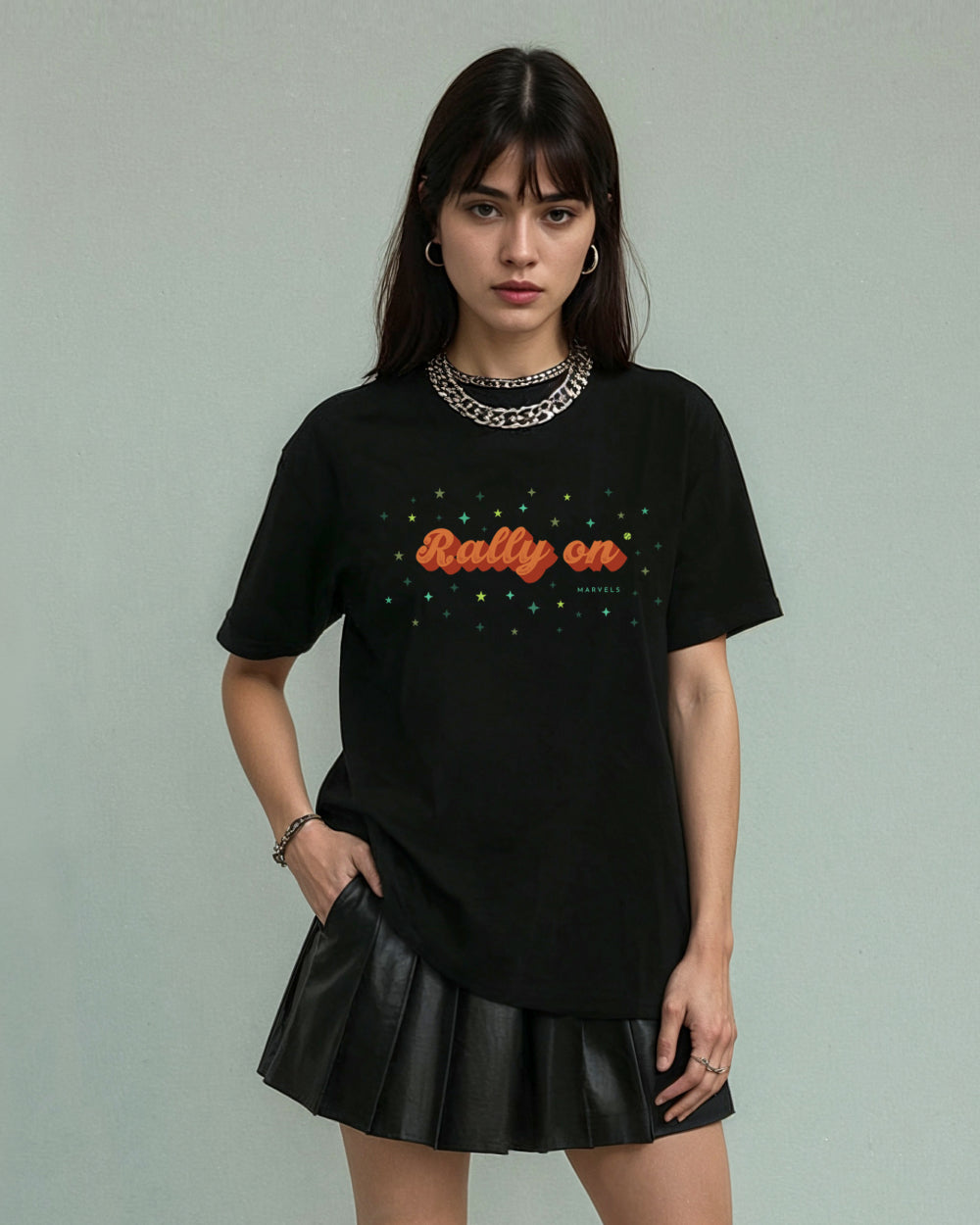 Model wearing a black tennis t-shirt with 'Rally On' text and a black skirt against a plain background