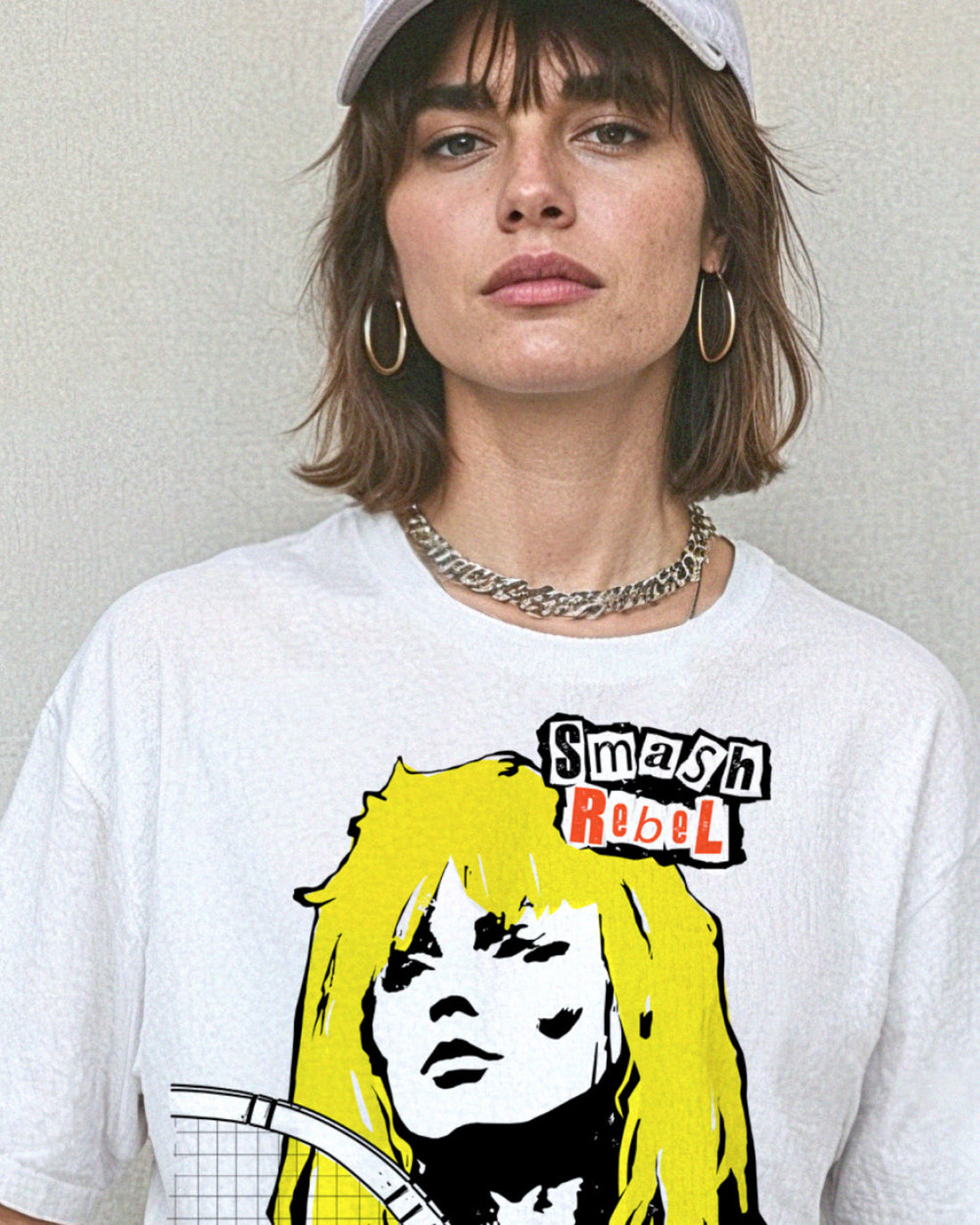 Person wearing a white t-shirt with a tennis-themed graphic that reads, 'Smash Rebel'.