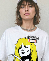 Person wearing a white t-shirt with a tennis-themed graphic that reads, 'Smash Rebel'.