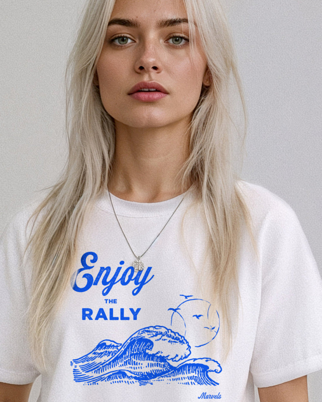 Model wearing a white t-shirt with a blue graphic that reads 'Enjoy the Rally' in text on a plain background