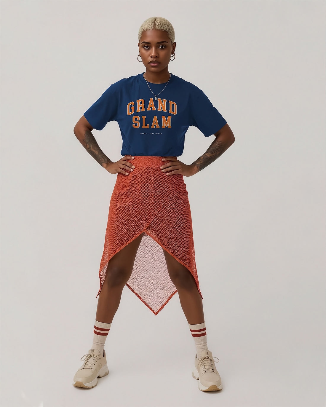 Person wearing a blue 'Grand Slam' t-shirt and orange skirt on a plain background