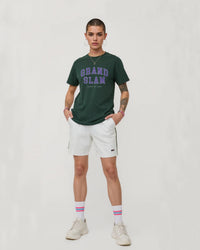 Person wearing a green 'Grand Slam' t-shirt and white shorts on a plain background