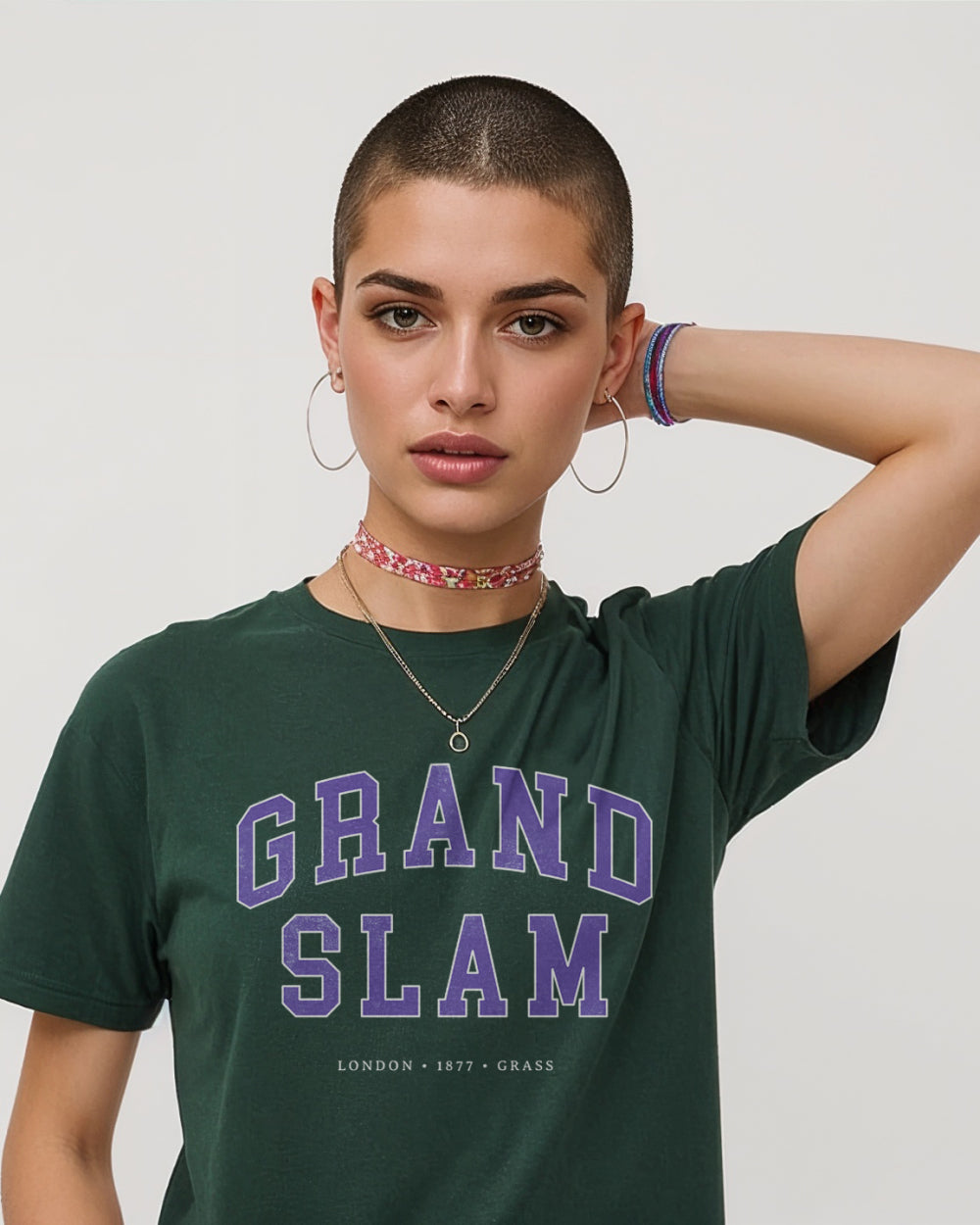 Person wearing a green 'Grand Slam' t-shirt with purple text on a plain background