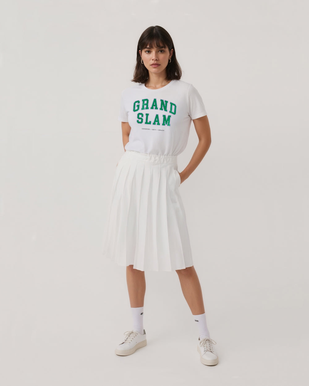 Person wearing a white t-shirt with 'Grand Slam' text on a plain background