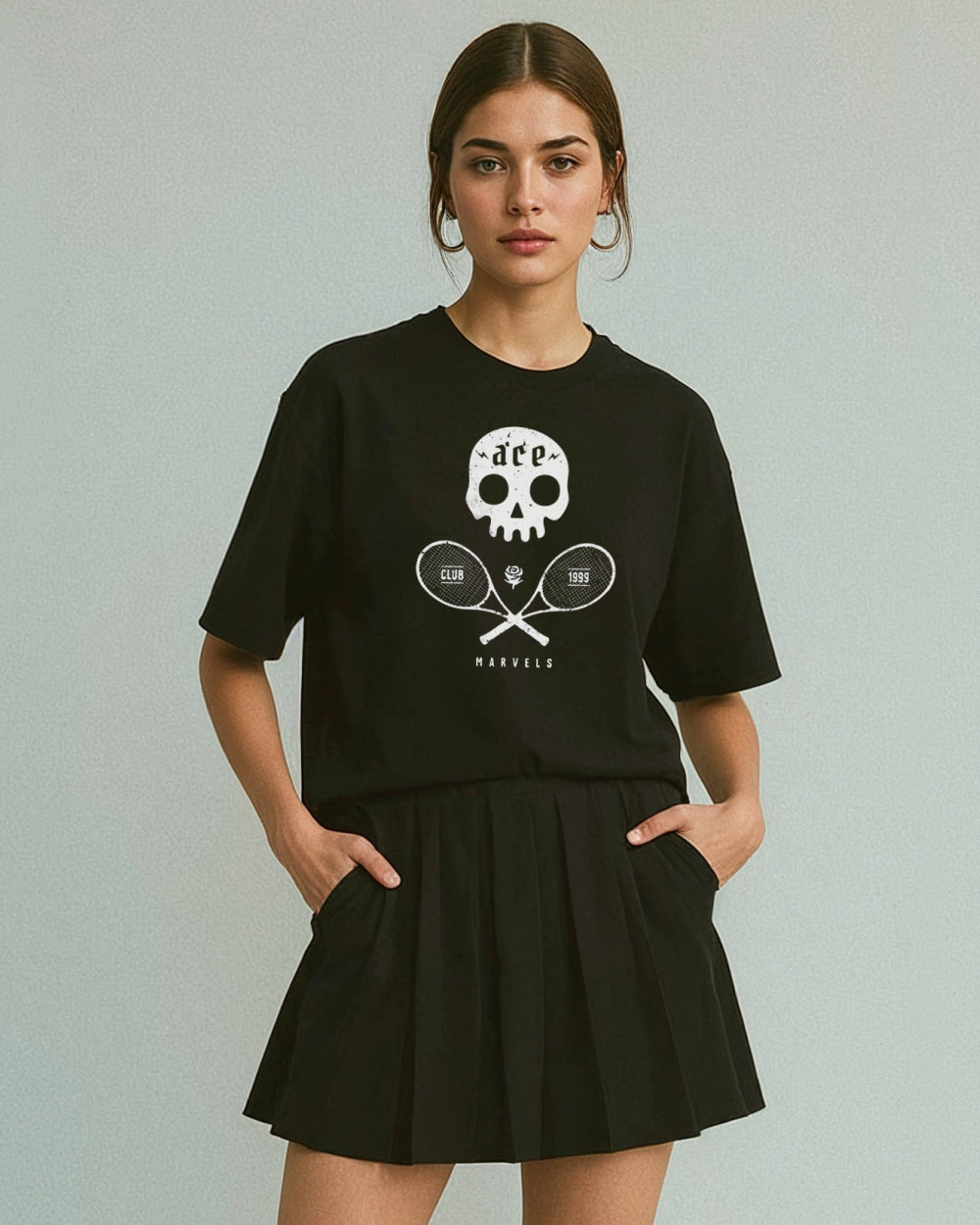 Woman wearing a black t-shirt with a skull and tennis racket design on a plain background