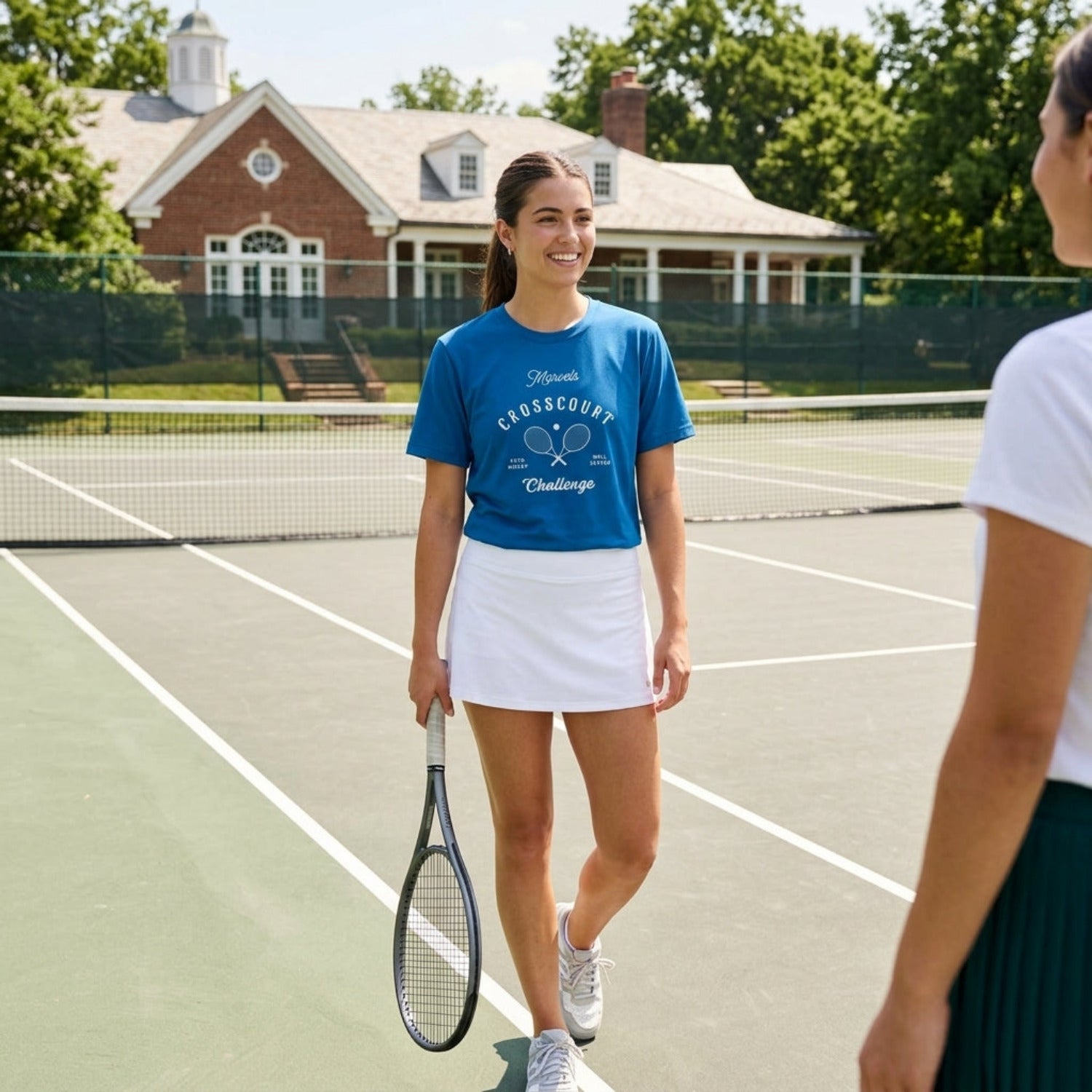 Woman on a tennis court holding a racket, wearing a blue t-shirt and white skirt.