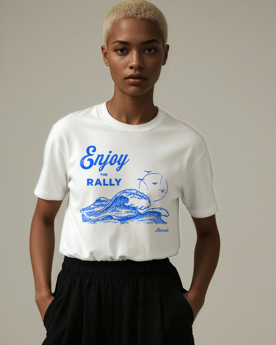 Person wearing a white t-shirt with blue tennis and surf graphics