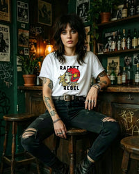 Person wearing a white t-shirt with graphic design sitting in a bar.